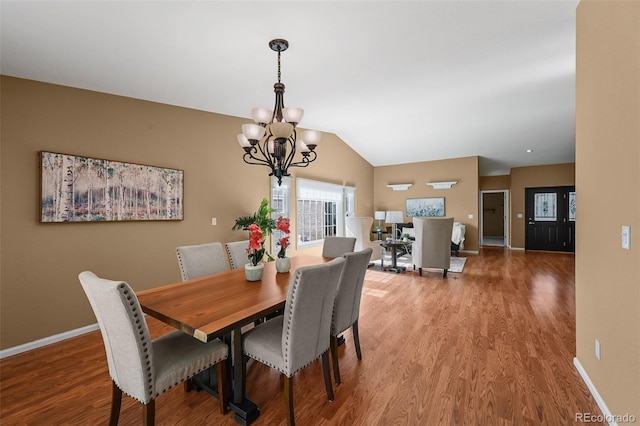 4927 Greenwich Way, Highlands Ranch, CO 80130 - dining area featuring a chandelier, wood finished floors, and lofted ceiling
