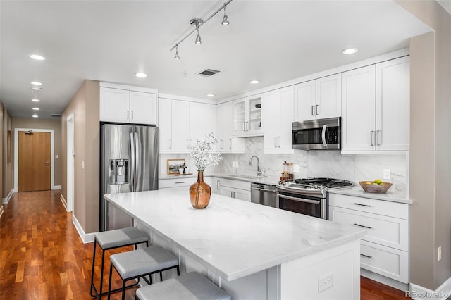 1631 N Emerson St Unit 117, Denver, CO 80218 - kitchen featuring recessed lighting, a kitchen breakfast bar, stainless steel appliances, visible vents, and a sink