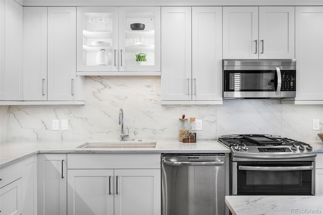 1631 N Emerson St Unit 117, Denver, CO 80218 - kitchen with backsplash, stainless steel appliances, white cabinets, and a sink