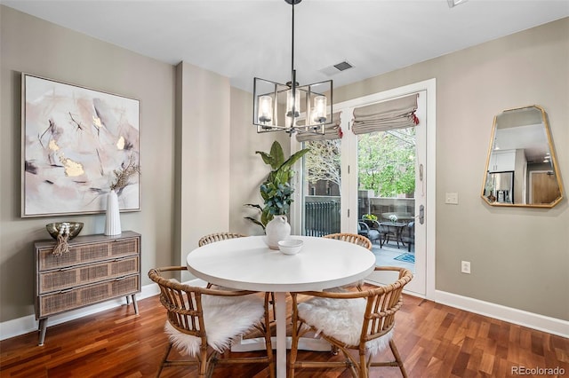 1631 N Emerson St Unit 117, Denver, CO 80218 - dining space featuring baseboards, a notable chandelier, wood finished floors, and visible vents