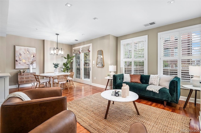 1631 N Emerson St Unit 117, Denver, CO 80218 - living area featuring a chandelier, a healthy amount of sunlight, baseboards, and visible vents