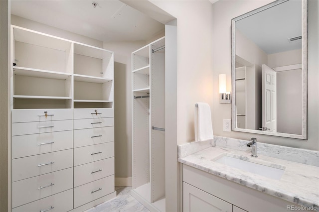 1631 N Emerson St Unit 117, Denver, CO 80218 - bathroom featuring a walk in closet, marble finish floor, and vanity