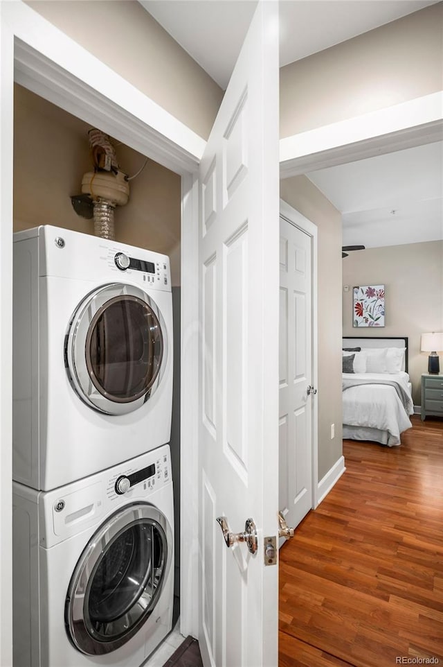 1631 N Emerson St Unit 117, Denver, CO 80218 - laundry area with baseboards, stacked washer / drying machine, and wood finished floors
