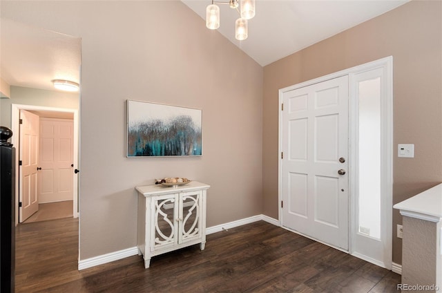 foyer with an inviting chandelier, vaulted ceiling, baseboards, and dark wood-style flooring