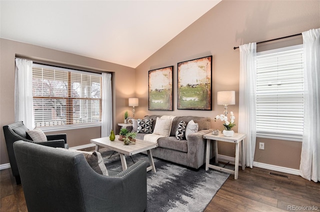 living area featuring visible vents, wood finished floors, baseboards, and vaulted ceiling