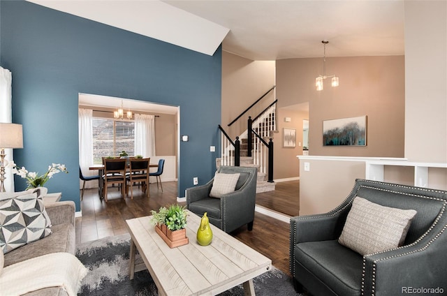 living room with an inviting chandelier, stairway, wood finished floors, and high vaulted ceiling