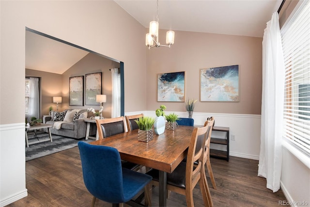 dining room featuring dark wood-style floors, a healthy amount of sunlight, an inviting chandelier, and vaulted ceiling