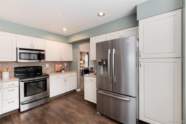 kitchen with backsplash, stainless steel appliances, light countertops, and dark wood-style flooring