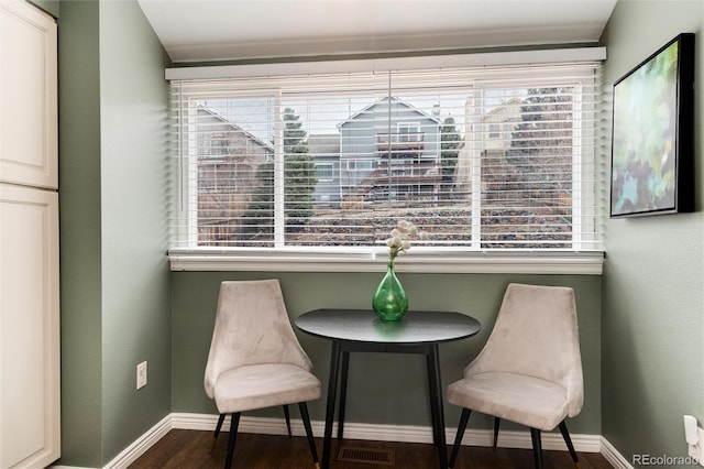 living area featuring visible vents, baseboards, and wood finished floors