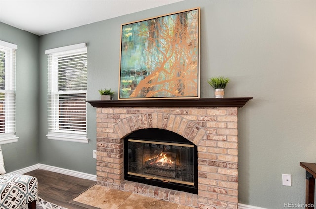 interior details featuring wood finished floors, a fireplace, and baseboards