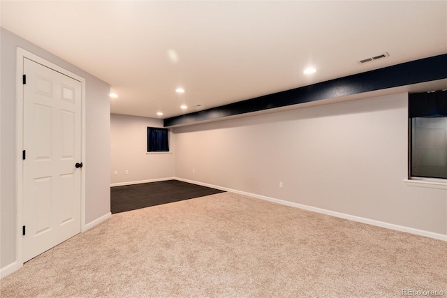 finished basement featuring recessed lighting, visible vents, and dark carpet