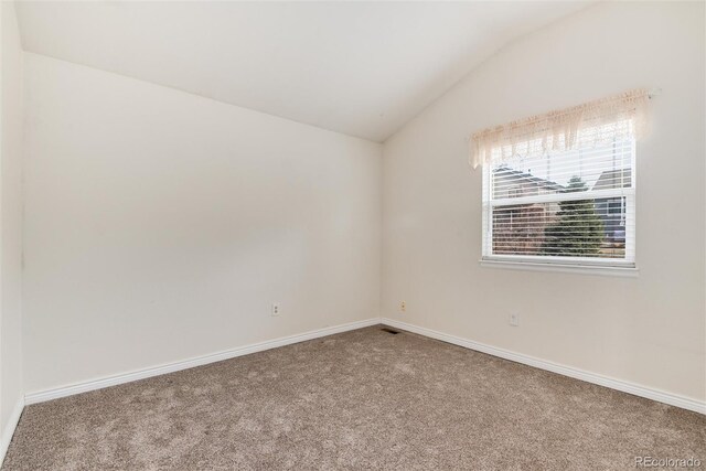 unfurnished room featuring baseboards, lofted ceiling, and carpet floors