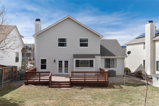 rear view of property with a lawn, a fenced backyard, french doors, roof with shingles, and central AC unit