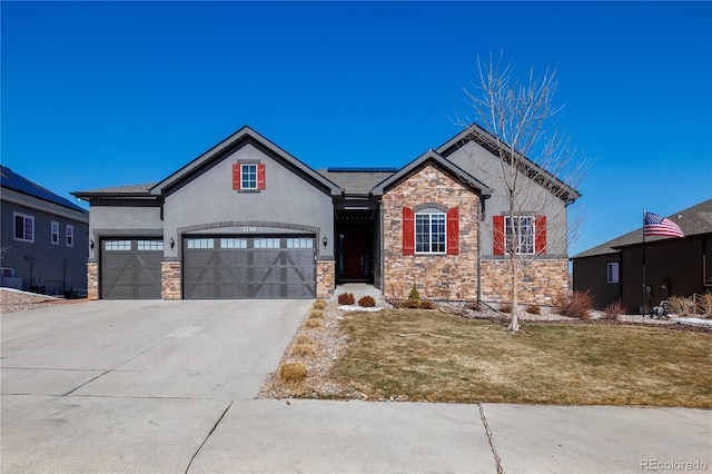 view of front of property with solar panels, a front lawn, concrete driveway, stucco siding, and stone siding