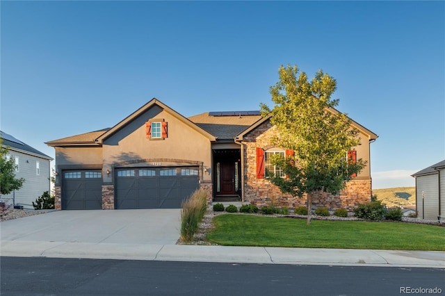 view of front of home with solar panels, stucco siding, concrete driveway, a front lawn, and stone siding