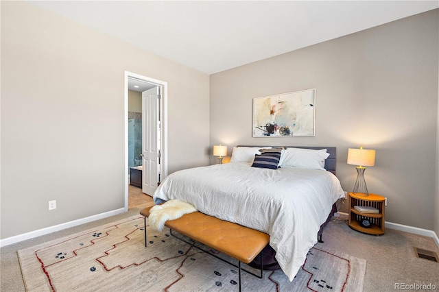 bedroom with carpet flooring, baseboards, visible vents, and ensuite bathroom