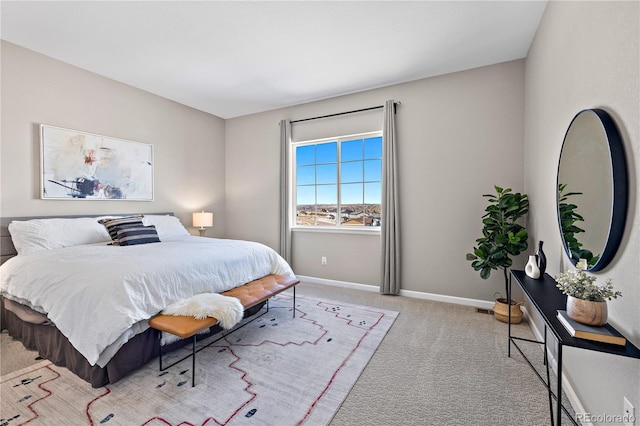 bedroom with baseboards and light carpet