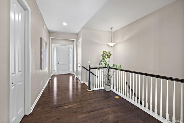 hallway with dark wood finished floors, recessed lighting, an upstairs landing, and baseboards