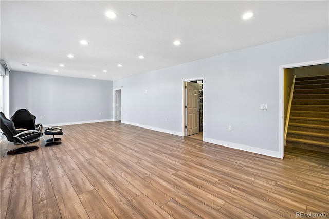 unfurnished room with stairs, recessed lighting, wood finished floors, and baseboards