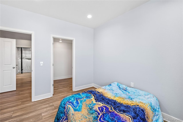 bedroom with recessed lighting, wood finished floors, and baseboards