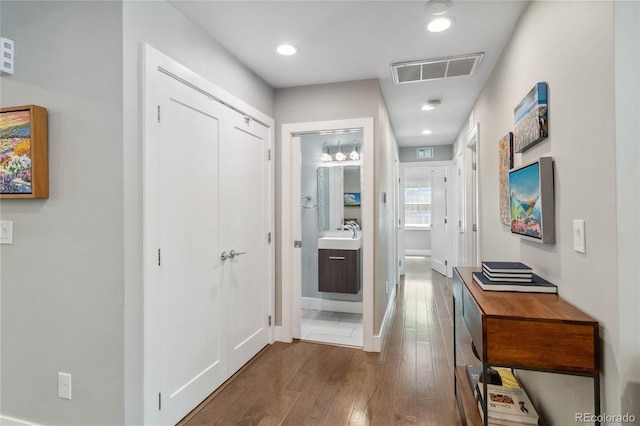 3040 S Dexter Way, Denver, CO 80222 - hallway featuring wood finished floors, baseboards, a sink, and recessed lighting