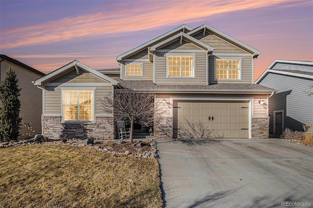 craftsman-style house featuring driveway, stone siding, and an attached garage