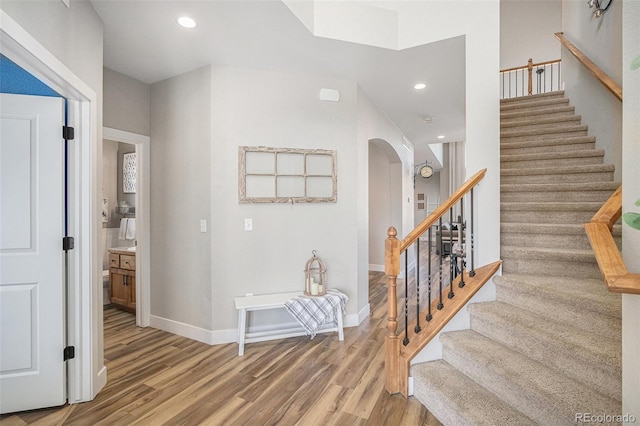 interior space with arched walkways, recessed lighting, baseboards, and wood finished floors