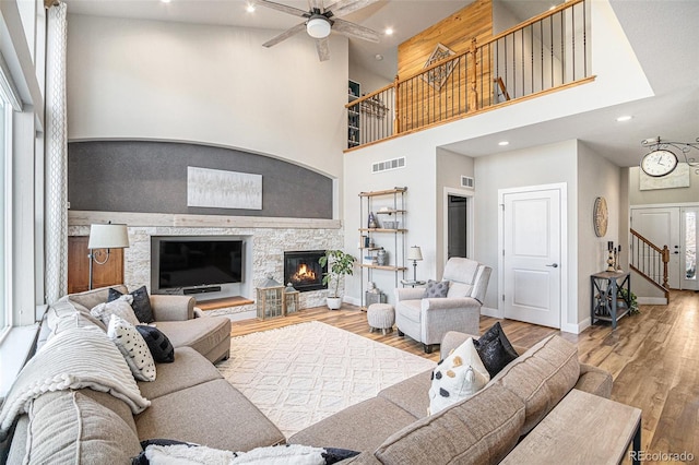 living area featuring a fireplace, wood finished floors, visible vents, and baseboards