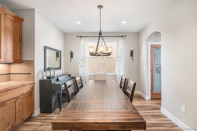 dining room featuring light wood-type flooring, an inviting chandelier, baseboards, and recessed lighting