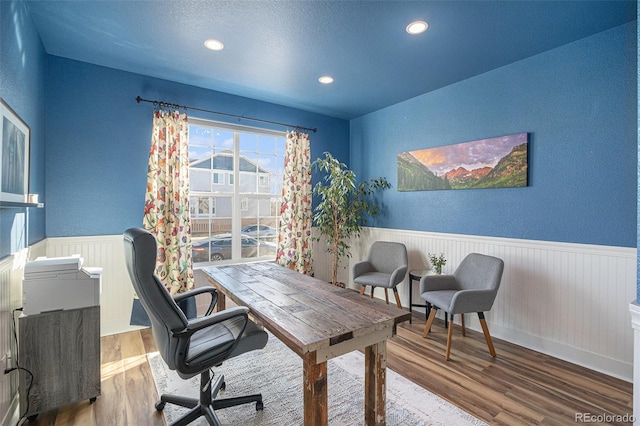 office space with a wainscoted wall, a textured ceiling, wood finished floors, and recessed lighting