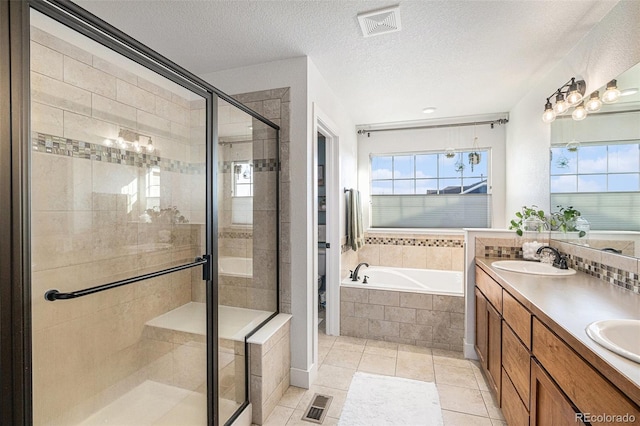 bathroom featuring a garden tub, visible vents, a sink, a shower stall, and a textured ceiling