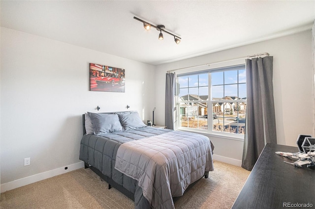 bedroom with baseboards and light colored carpet