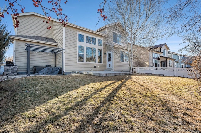 back of house with a pergola, a patio, a lawn, and fence