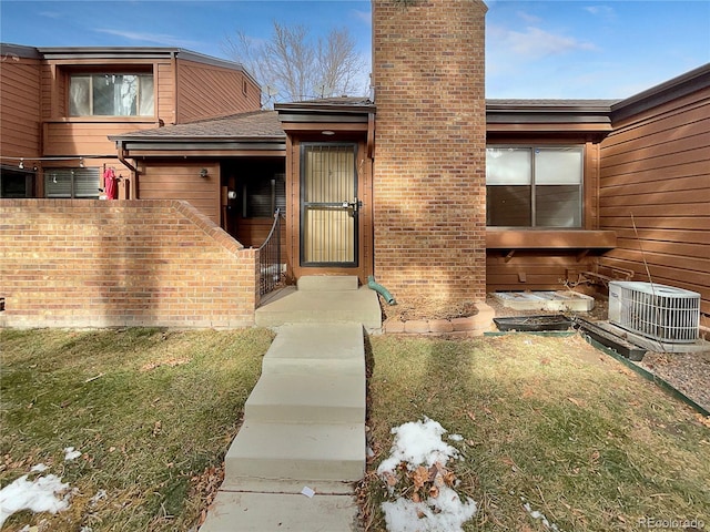 doorway to property featuring a yard and central AC