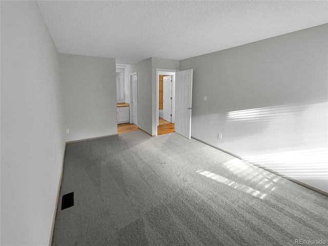 carpeted spare room with a textured ceiling