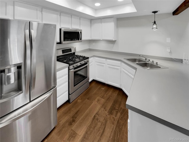 kitchen with sink, white cabinetry, decorative light fixtures, appliances with stainless steel finishes, and dark hardwood / wood-style floors