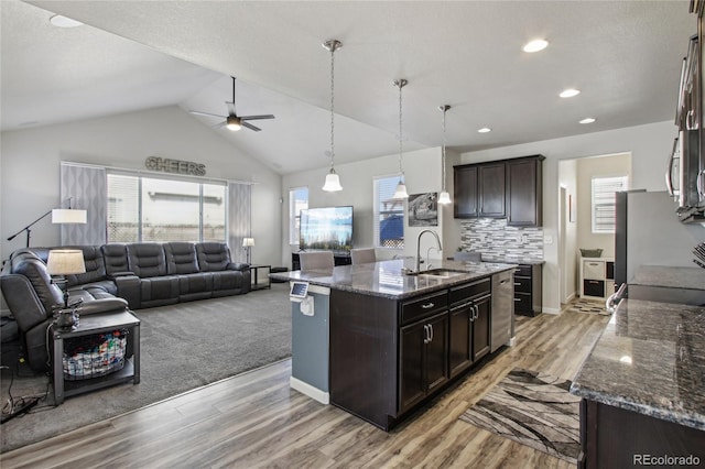 kitchen with a sink, a ceiling fan, light wood-type flooring, and open floor plan