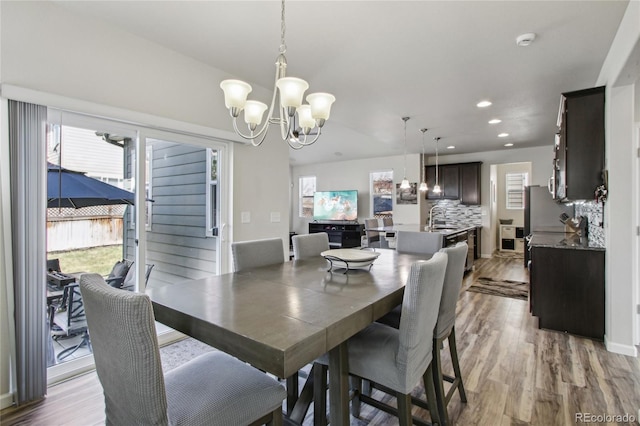 dining room with recessed lighting, plenty of natural light, light wood finished floors, and a chandelier