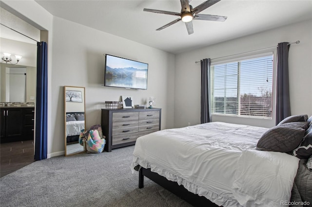 carpeted bedroom featuring baseboards and ceiling fan with notable chandelier