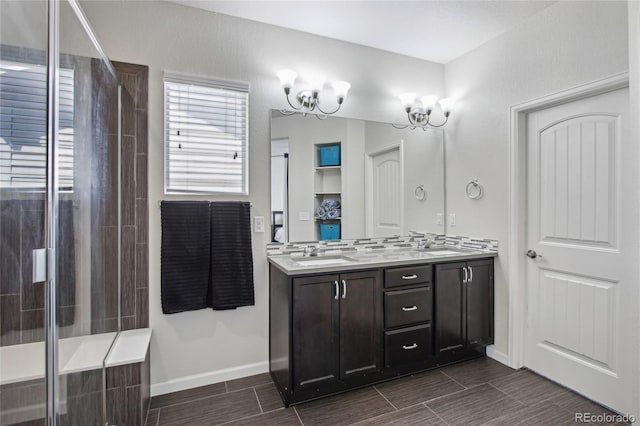 bathroom with double vanity, baseboards, wood finish floors, a sink, and a tile shower