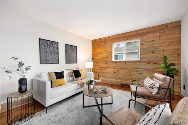 living area with wooden walls and wood finished floors