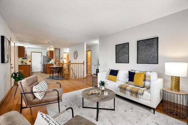 living area featuring light wood-type flooring and ceiling fan