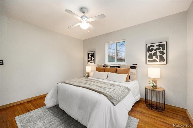 bedroom featuring ceiling fan, baseboards, and wood finished floors