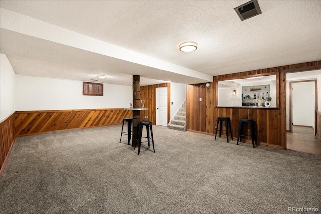 playroom featuring visible vents, wooden walls, and carpet flooring