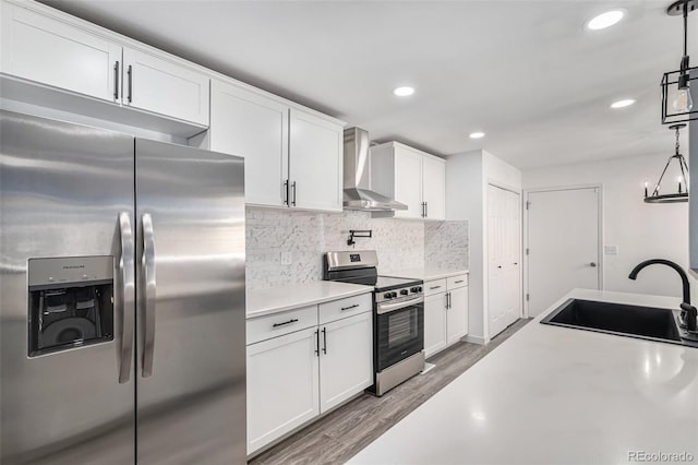 10000 E Yale Ave Unit 58, Denver, CO 80231 - kitchen with appliances with stainless steel finishes, wall chimney exhaust hood, light countertops, light wood-style floors, and decorative backsplash