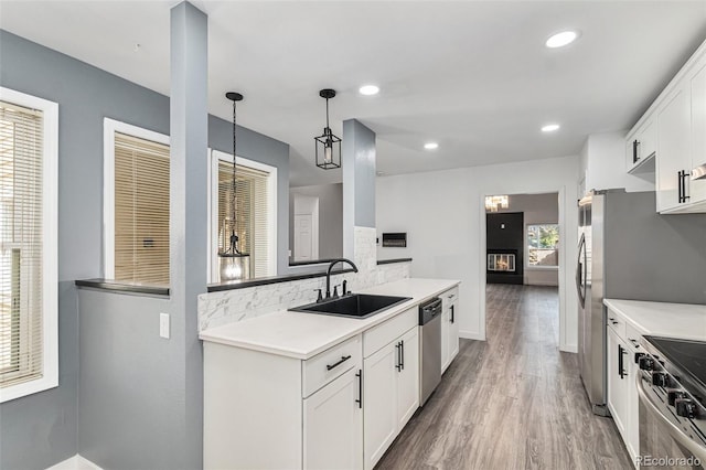 10000 E Yale Ave Unit 58, Denver, CO 80231 - kitchen with stainless steel appliances, wood finished floors, white cabinets, tasteful backsplash, and light countertops