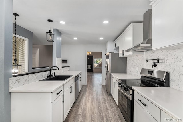 10000 E Yale Ave Unit 58, Denver, CO 80231 - kitchen featuring stainless steel appliances, wall chimney exhaust hood, light wood-style flooring, tasteful backsplash, and recessed lighting