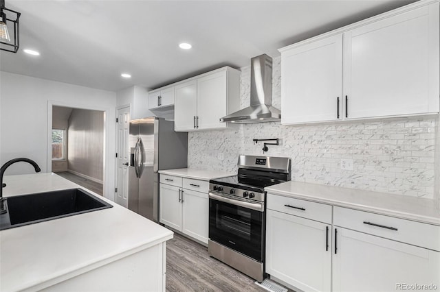 10000 E Yale Ave Unit 58, Denver, CO 80231 - kitchen featuring wall chimney exhaust hood, stainless steel appliances, white cabinets, backsplash, and light countertops