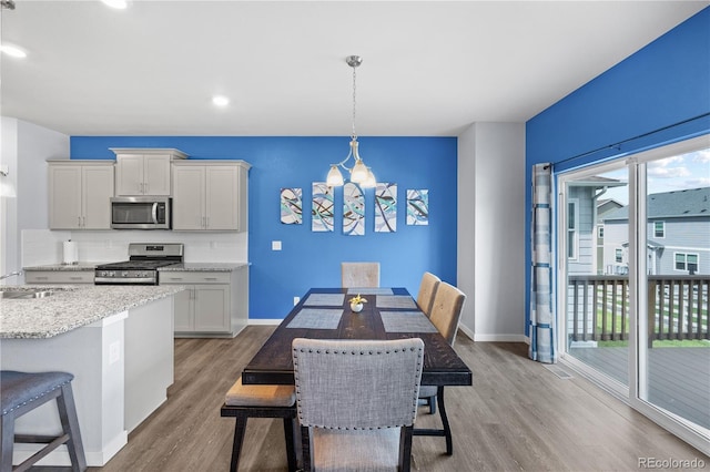 2144 Rosette Ln, Castle Rock, CO 80104 - dining area with a chandelier, plenty of natural light, light wood-type flooring, baseboards, and recessed lighting