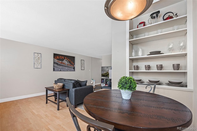 dining room with built in features and light hardwood / wood-style flooring